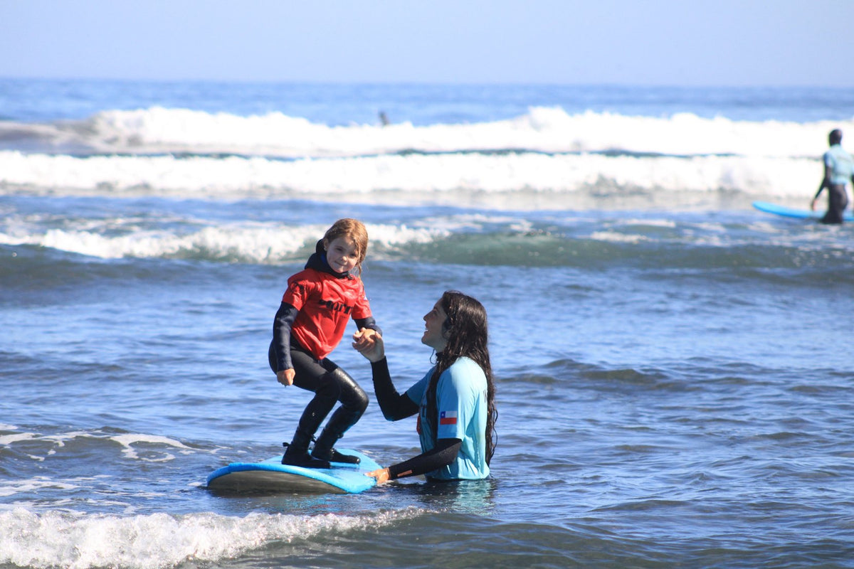 Instructora acompañando a una niña en el agua