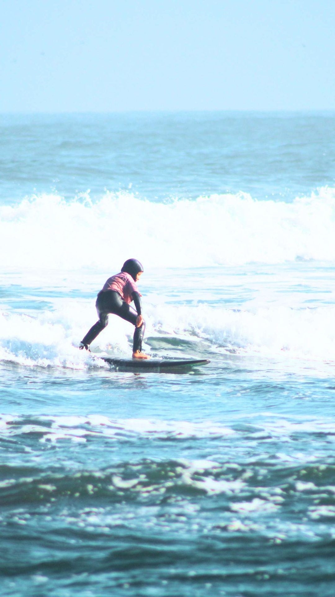 Niña surfeando una ola en la Academia de Verano Storm